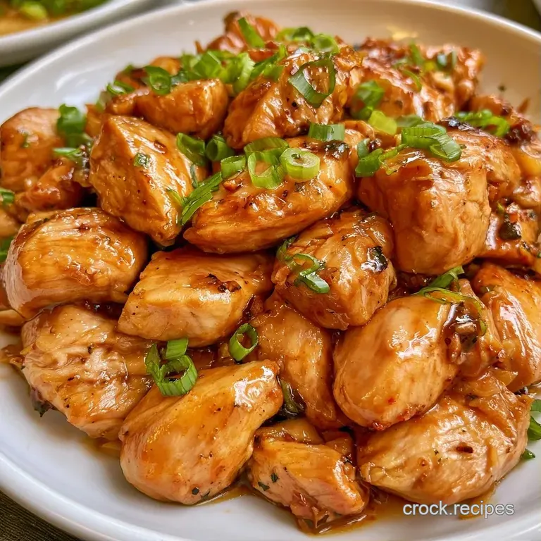 Saut&eacute;ed chicken and colorful peppers served in a minimal white bowl, garnished with crisp peanuts and scallions.